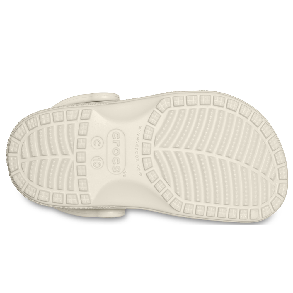 Underside of single Crocs clogs in bone with size C10 written on grippy sole