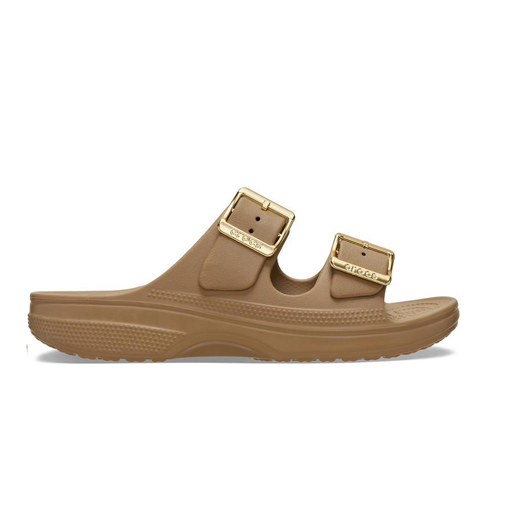 A single tan Crocs slide sandal with two adjustable straps and gold-tone buckles, shown in a side profile on a white background.