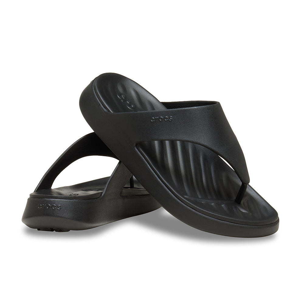 A pair of black Crocs flip-flop sandals with a molded, ribbed design, displayed on a clean white background.