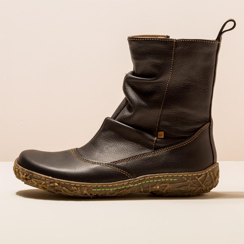 Black leather boot on a beige background