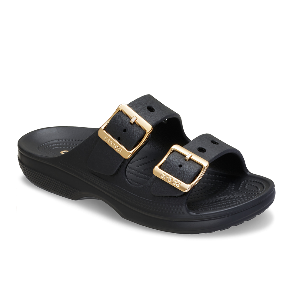 A black double-strap slide sandal with gold-tone buckle details, shown from a three-quarters angle on a white background.